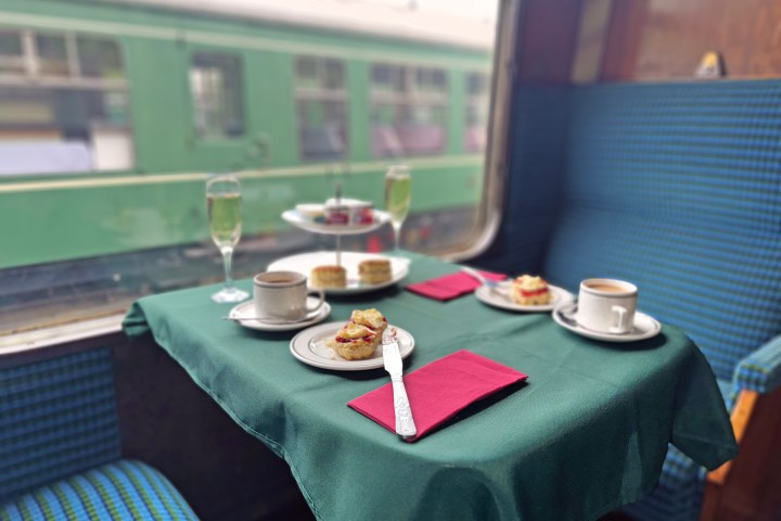 Cream tea with prosecco on a train table by a window.