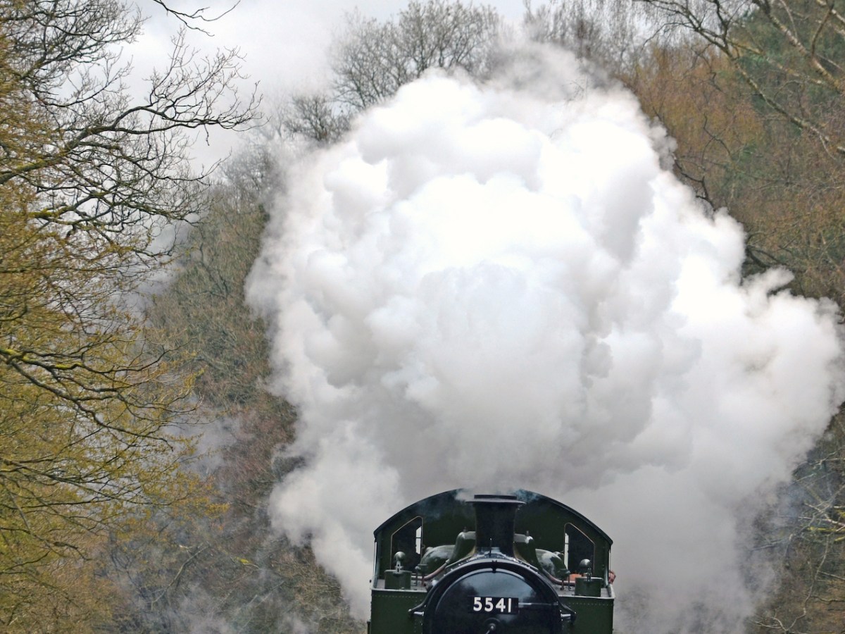 a steam train on a track with smoke coming out of it