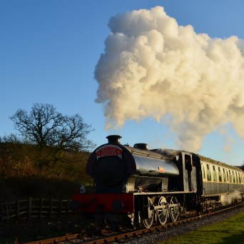 a steam train on a track with smoke coming out of it