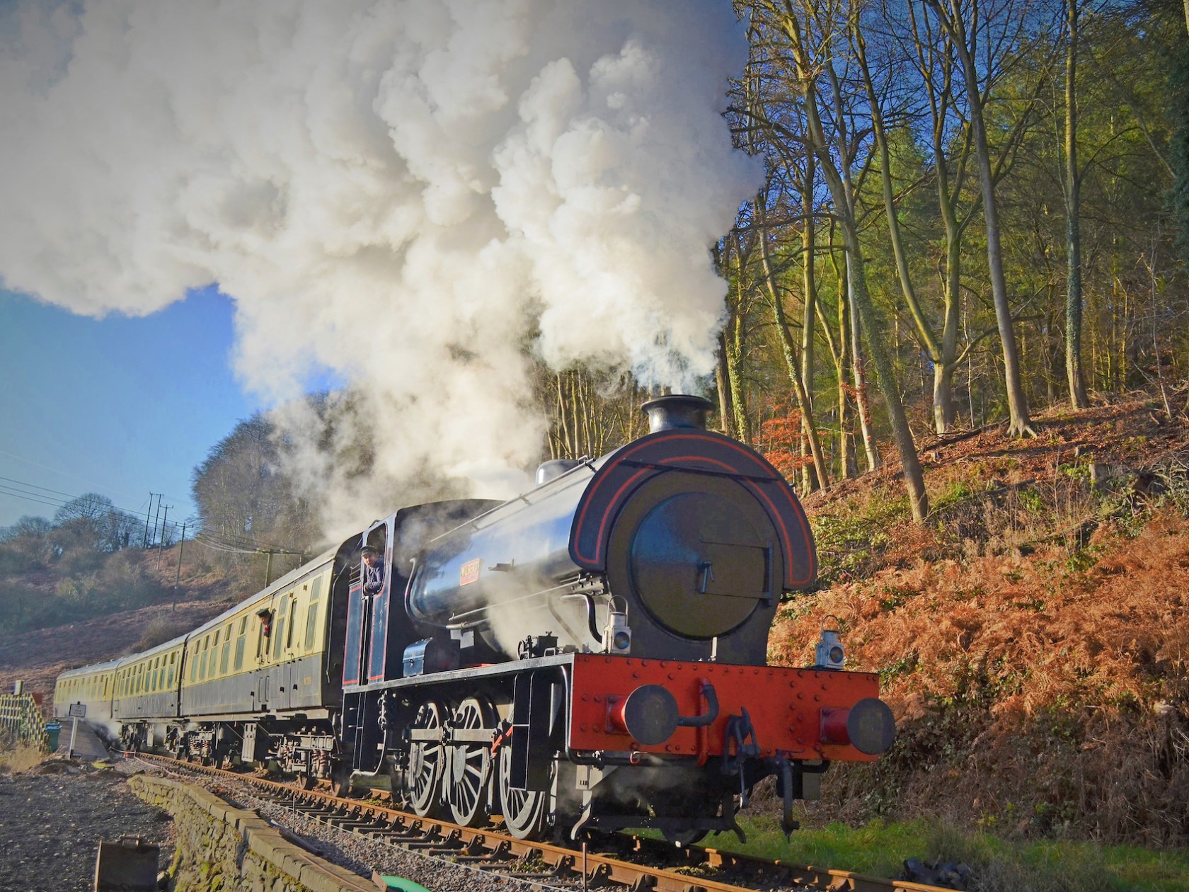a steam train on a track with smoke coming out of it