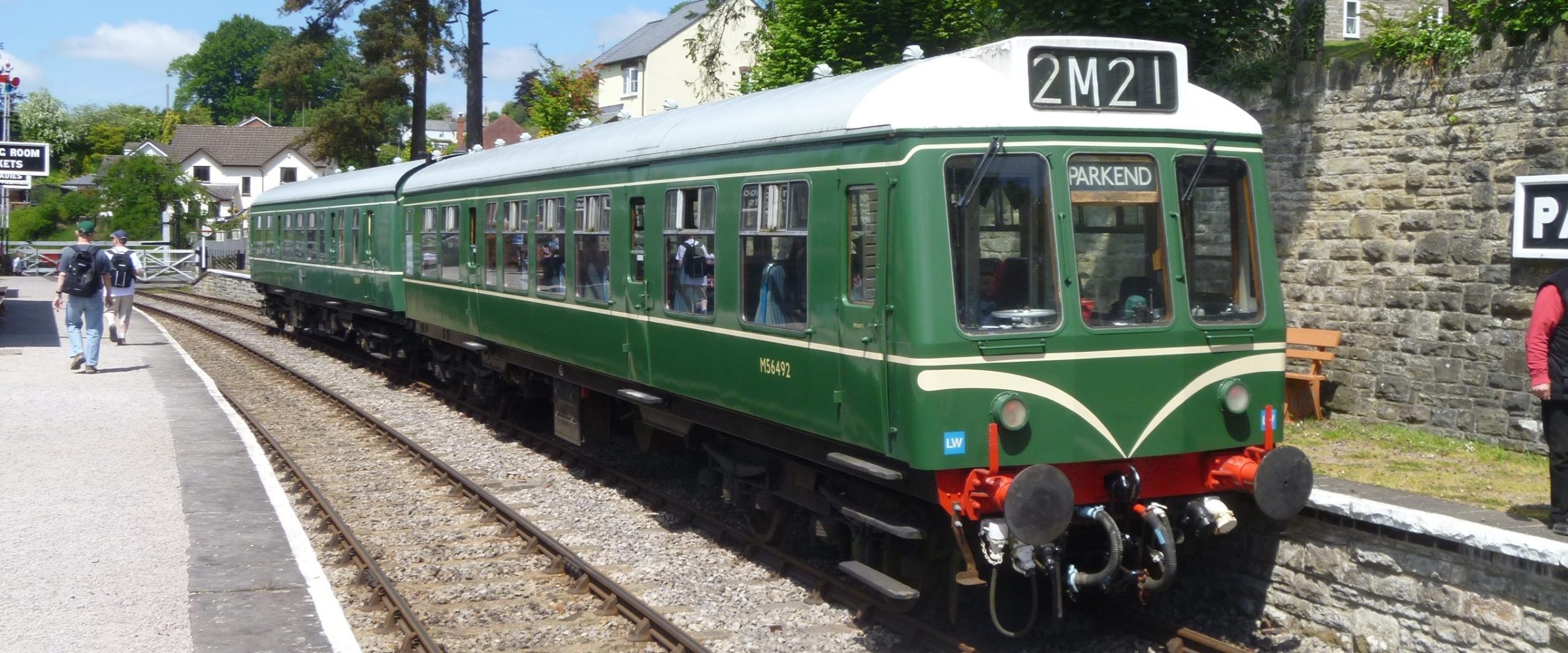 a green train that is sitting on a railroad track