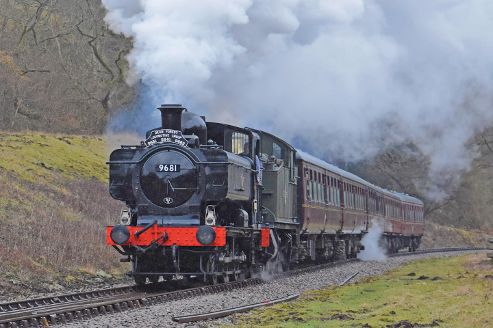 a steam train on a track with smoke coming out of it